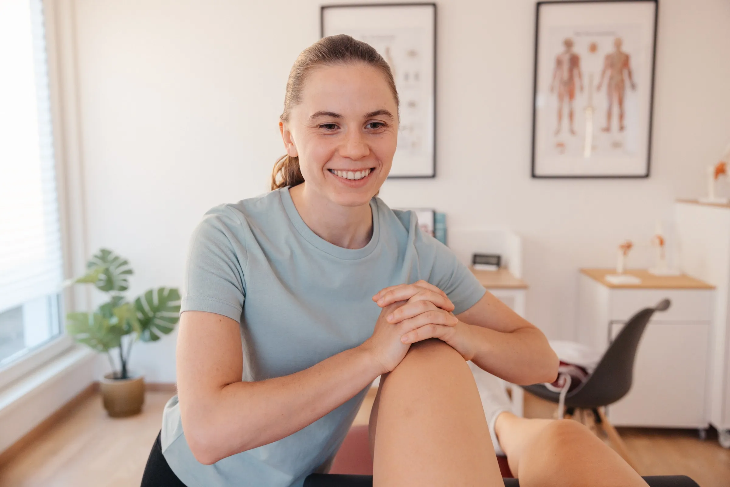 Therapeutin behandelt das Knie einer Patientin