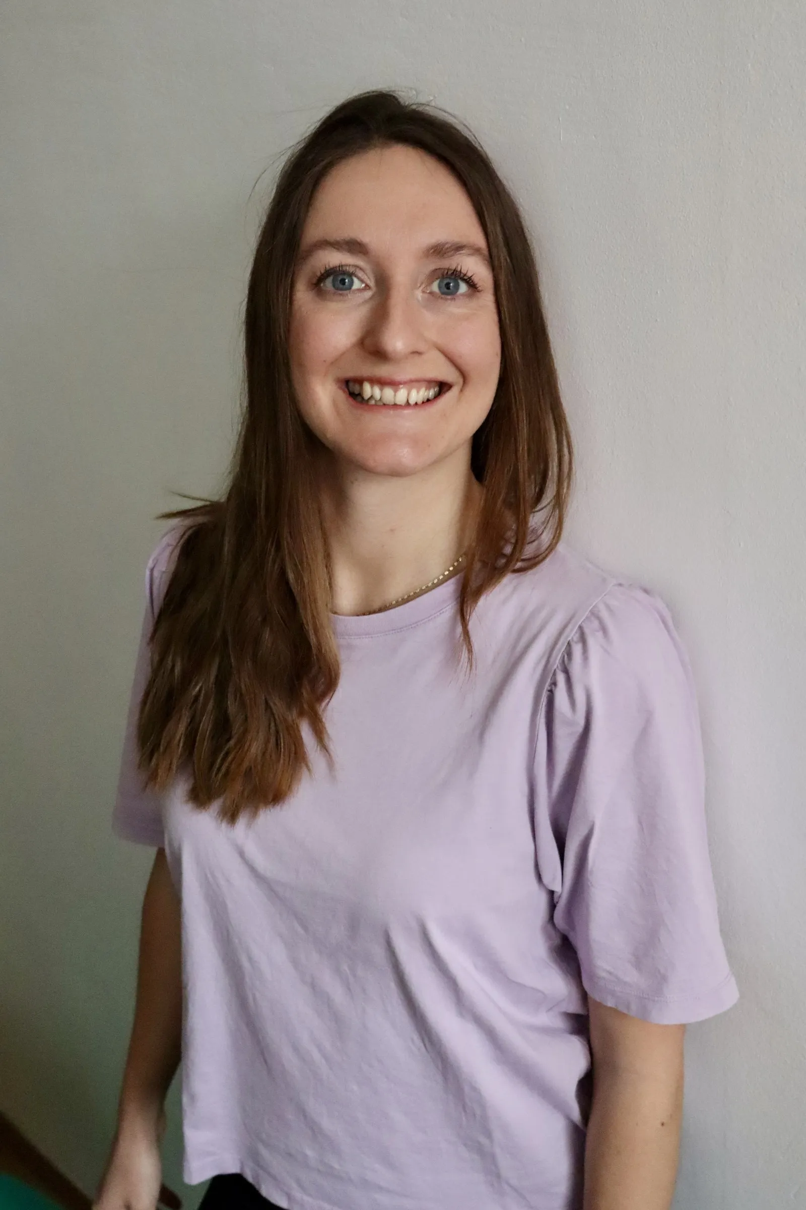 Kristina Haslinger lächelt in die Kamera, im Hintergrund eine helle Wand