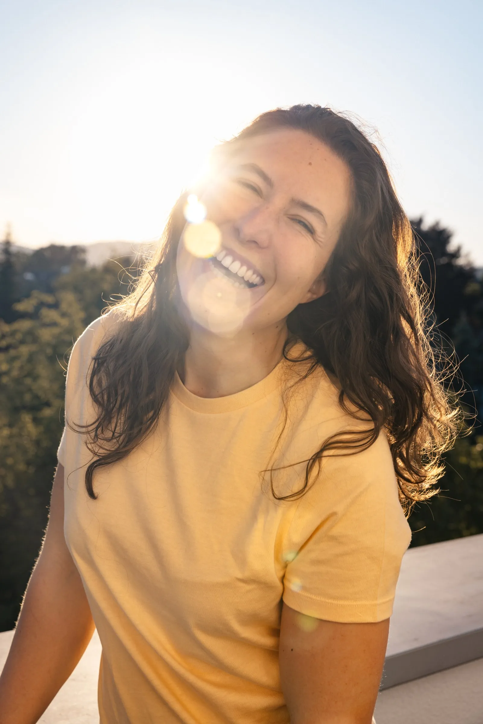 Sarah Kandolf lacht im Gegenlicht auf der Dachterrasse der Praxis