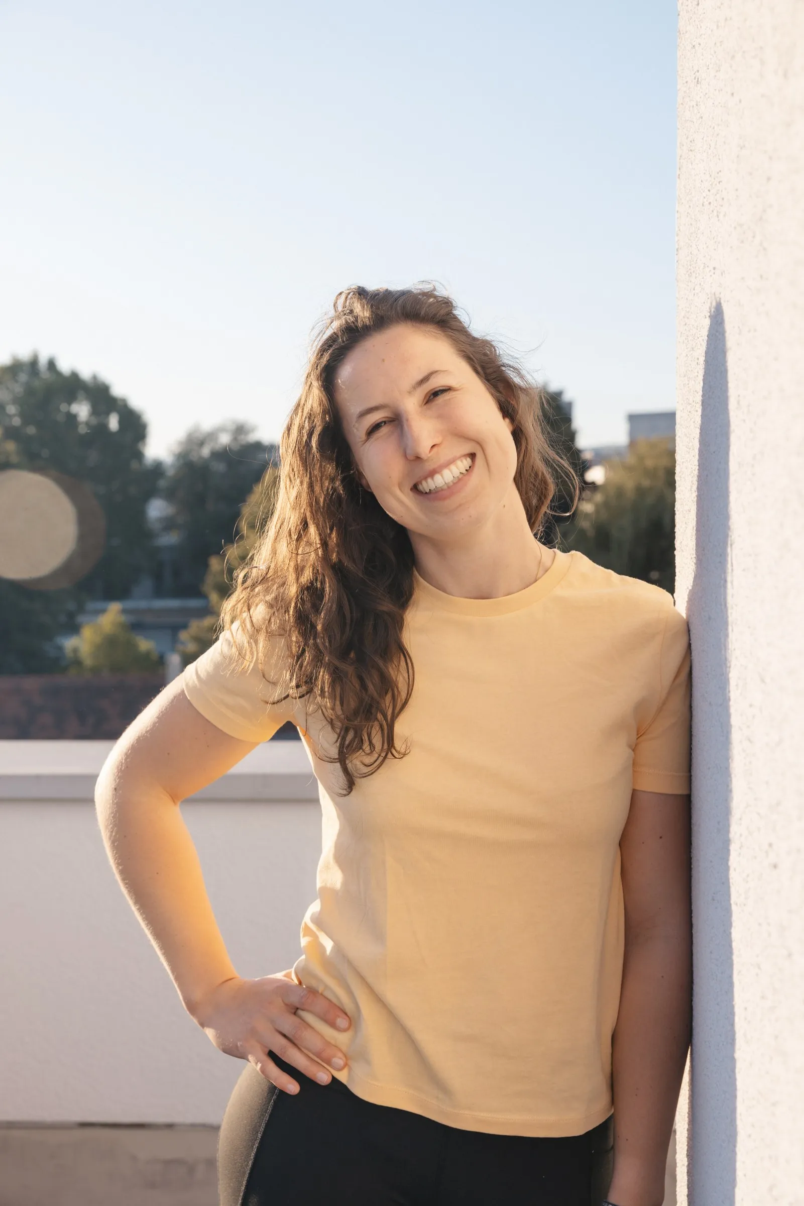 Sarah Kandolf steht mit der Hand in der Hüfte auf der Dachterrasse der Praxis