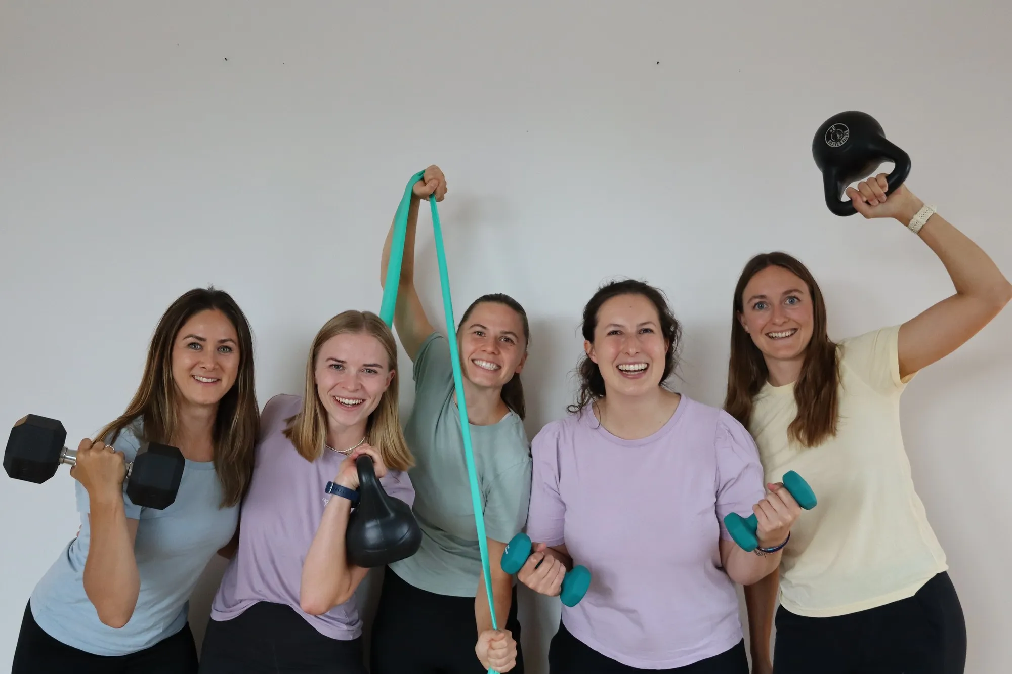 Das Team mit Kettlebells, Kurzhanteln und einem Trainingsband